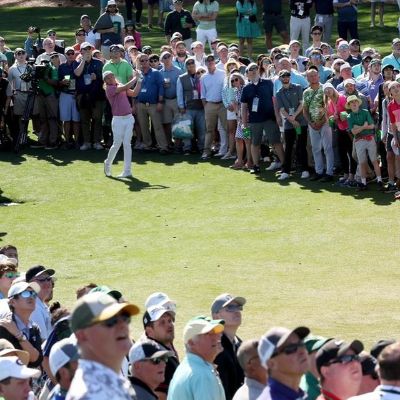 Cameron Smith has just hit a shot as spectators are looking at the golf ball.